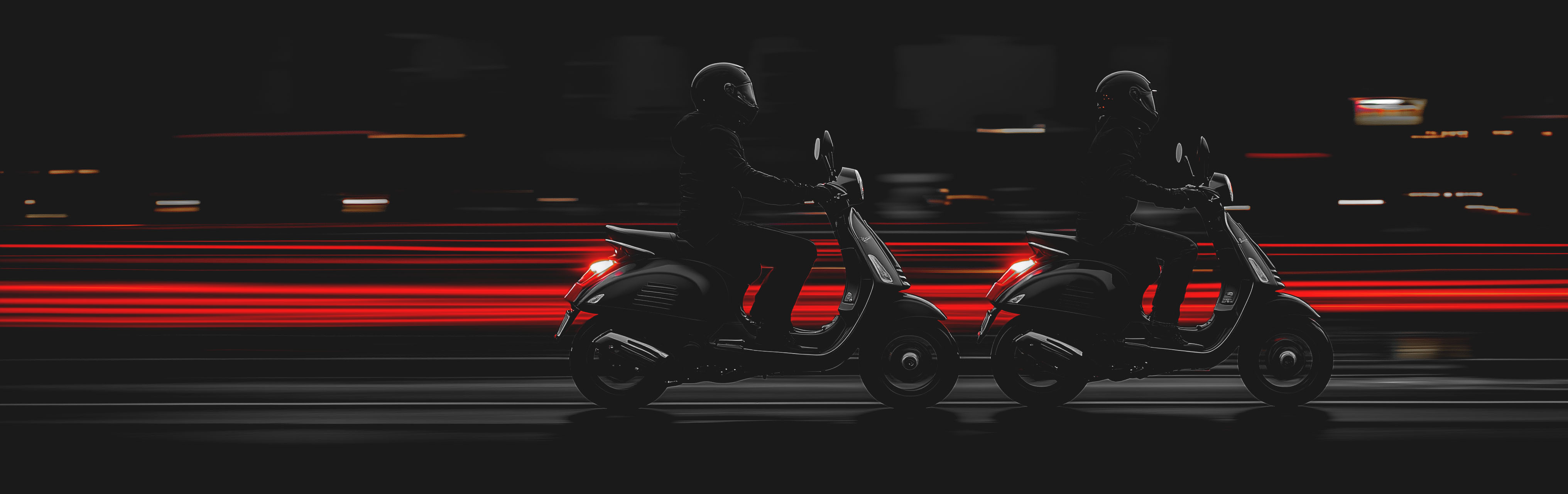 Panoramic photo of two people riding Vespa scooters at night